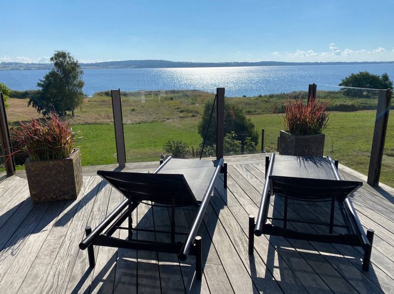 Terrasse med liggestole og panoramaudsigt over Tissø